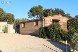 a small wooden house with a gravel driveway at Chalet de charme climatisé sur la route du Ventoux in Carpentras
