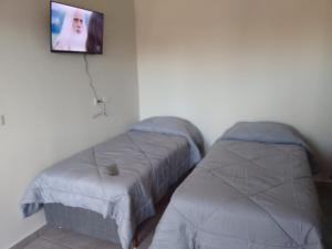 a bedroom with two beds and a tv on the wall at Canoas Hotel in Três Lagoas +16 photos