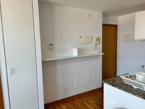 a kitchen with white walls and a counter top at Playa Miño in Miño
