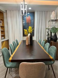 a dining room table with green chairs and a dining room at Lux Ph & Rooftop Terrace to Relax in Santiago de los Caballeros