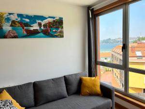 a living room with a couch and a large window at Playa Miño in Miño