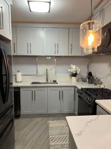 a kitchen with white cabinets and a sink and a stove at Lux Ph & Rooftop Terrace to Relax in Santiago de los Caballeros +11 photos