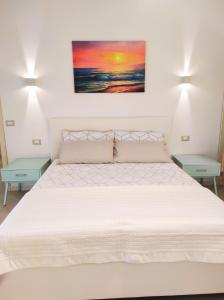 サン・メナイオにあるDeluxe Romantic Suiteのベッドルーム1室(白い大型ベッド1台、テーブル2台付)