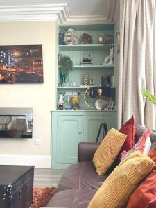 a living room with a couch and some shelves at Sunny View in Aberystwyth