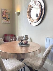 a dining room table with chairs and a mirror at Sunny View in Aberystwyth