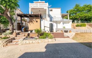 een huis met een loopbrug ervoor bij Amazing Apartment In Stara Novalja in Stara Novalja +25 foto's
