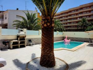 a palm tree with a pink flamingo next to a pool at Luxury Private New 2023 Villa Mirelle in Torrevieja