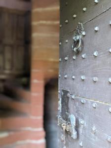 uma velha porta de madeira com uma corrente em Château de Vassinhac chambres d'hôtes Collonges la rouge em Collonges