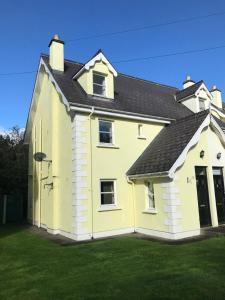 a large yellow house with a black roof at No 3 Aughrim Holiday Village in Aughrim