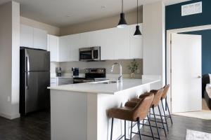 a kitchen with white cabinets and a counter with bar stools at Kasa Archive Reno-Tahoe in Reno