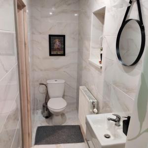 een witte badkamer met een toilet en een wastafel bij Nest in Spišská Nová Ves