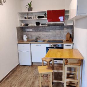 a small kitchen with white appliances and a wooden table at Nest in Spišská Nová Ves +20 photos