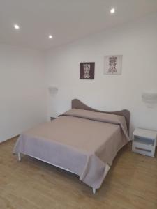 Un dormitorio con una cama y una pared blanca. en Sikelia Etna House, en Zafferana Etnea
