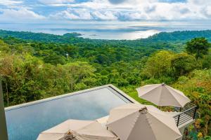 un balcón con sombrillas y vistas al océano. en Amigos Por La Vida en Dominical