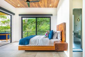 - une chambre avec un lit et une porte en verre dans l'établissement Amigos Por La Vida, à Dominical
