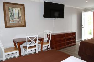 1 dormitorio con escritorio, 1 cama y vestidor en The Burgundy Inn Hotel and Apartments, en Ocean City