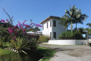 una casa blanca con palmeras y flores en Casa Hacienda Jaguar, en Ojochal