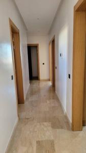 un couloir d'une pièce vide avec des portes et du carrelage dans l'établissement Luxurious 3BR 1,5Bath flat near the beach, à Agadir