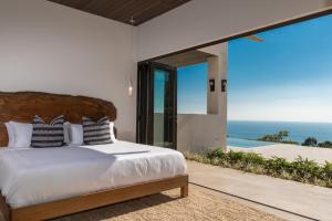 a bedroom with a bed and a view of the ocean at RESOL Secluded Ocean-view luxury in the Jungle in Uvita