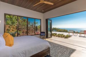 a bedroom with a bed and a view of the ocean at RESOL Secluded Ocean-view luxury in the Jungle in Uvita