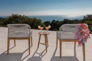 two chairs and a table with two glasses of wine at RESOL Secluded Ocean-view luxury in the Jungle in Uvita