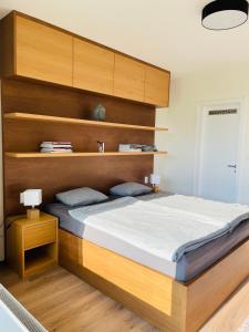 a bedroom with a large bed with wooden shelves at Šumavský apartmán - Nový komfortní a prostorný, se zahradou in Stachy