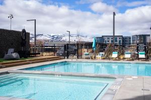 a swimming pool at a hotel with mountains in the background at Kasa Archive Reno-Tahoe in Reno