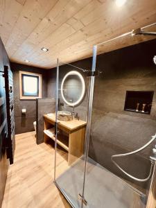 a bathroom with a shower with a mirror and a sink at Le Refuge Cal Chalon , chalet de luxe au cœur du village in Les Angles