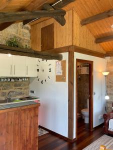 奧倫塞的住宿－Da man da Moura，厨房配有白色冰箱和墙上的时钟