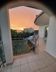een balkon van een huis met een zonsondergang op de achtergrond bij Dalmas apartmani in Vela Luka
