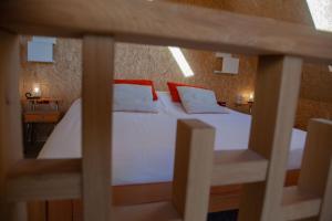 OosterendにあるSilver Gardenのベッドルーム(白いベッド、赤い枕付)