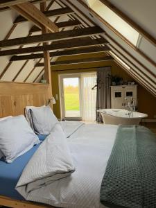 um quarto com uma cama grande e uma banheira em Hústerheide em Noordbergum