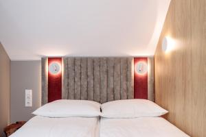 a bedroom with a bed with two lights above it at SKARPA resort in Ustronie Morskie