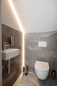 Łazienka z białą toaletą i umywalką w obiekcie SKARPA resort w mieście Ustronie Morskie