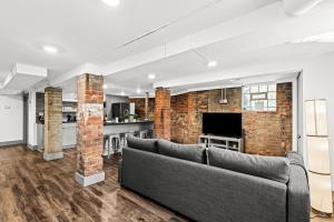 a living room with a couch and a brick wall at The Midtown Hideaway in Detroit