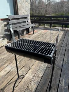 een grill op een terras naast een bank bij La casita de Las Trancas in Pinto