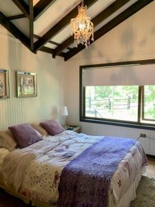 a bedroom with a large bed with a large window at La casita de Las Trancas in Pinto
