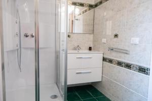 bagno bianco con doccia e lavandino di NONNU NONNA a Padru