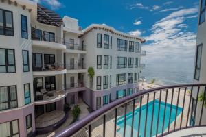 a view of the ocean from the balcony of a building at Diamante Beachfront Suites in San Pedro