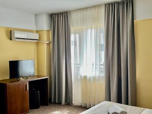 a hotel room with a bed and a window at Casa Mario in Eforie Nord