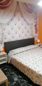 een slaapkamer met een groot bed met een muur bij Céline in Genua