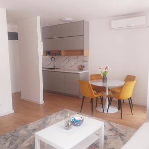 un soggiorno con tavolo e cucina di Apartman Neyla a Mostar