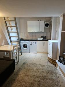 a kitchen with a washer and dryer in a room at Armhurst in London
