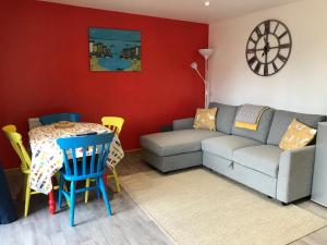 uma sala de estar com um sofá e uma mesa em Woodpecker Glamping Cabin em Bodmin