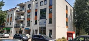 a white building with cars parked in front of it at Apartament MONDRIAN in Płock
