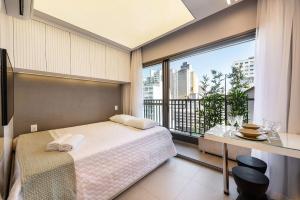 a bedroom with a bed and a large window at VNC13 Conforto e Estilo Perto do Metrô Anhangabaú in Sao Paulo