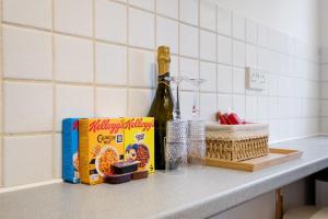 una barra de cocina con una caja de cereales y una botella de vino en Harry Potter, Warner Brothers Apartment - Watford Junction - Watford FC - Free Parking, en Watford