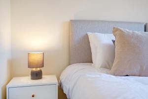 1 dormitorio con cama y mesita de noche con lámpara en Harry Potter, Warner Brothers Apartment - Watford Junction - Watford FC - Free Parking, en Watford