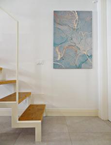 ein Zimmer mit einer Treppe und einem Gemälde an der Wand in der Unterkunft CLASSY HOMES - Acquamarina in Sanremo