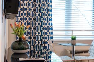 um quarto com um vaso numa mesa com uma janela em Oceanside Hotel and Suites em Miami Beach